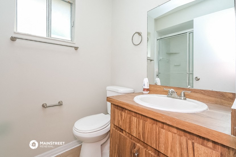 a bathroom with a sink toilet and a mirror