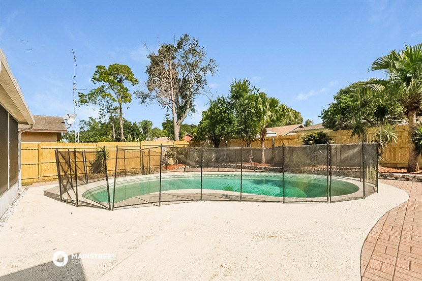 a small pool in a fenced in backyard with a chainlink fence and a