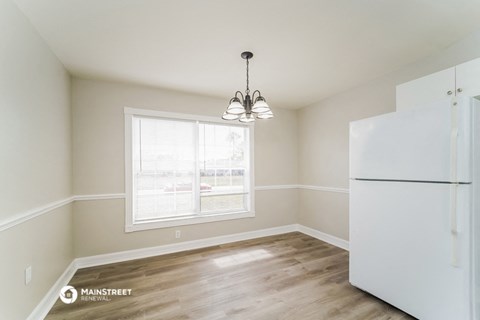 a kitchen with a large window and a white refrigerator