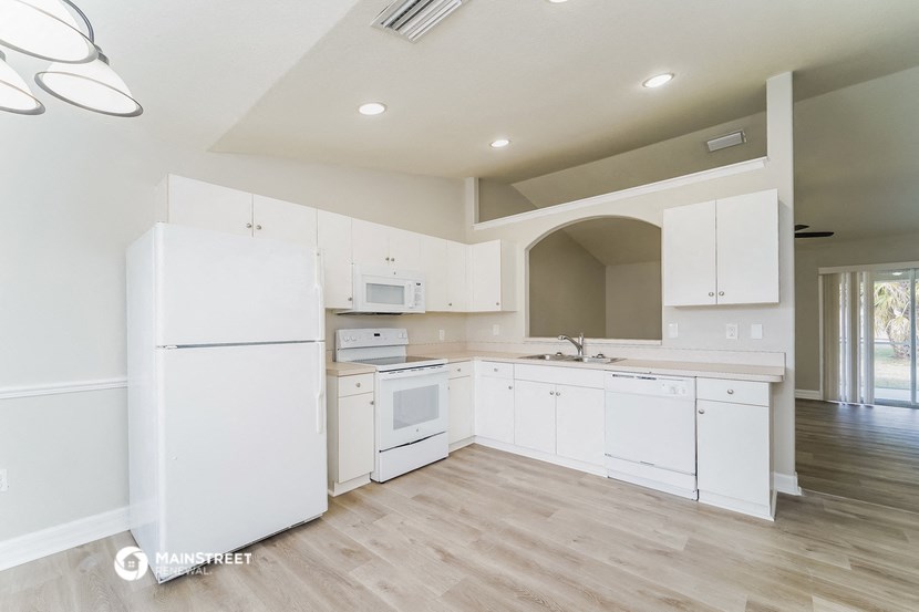 a white kitchen with white appliances and white cabinets