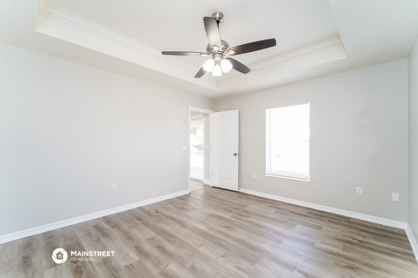 an empty living room with a ceiling fan