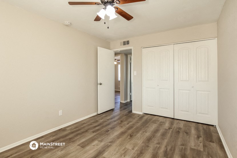 the living room of an empty house with a ceiling fan