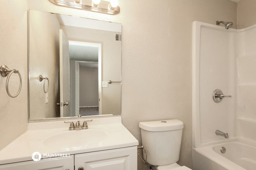 a bathroom with a sink toilet and a mirror