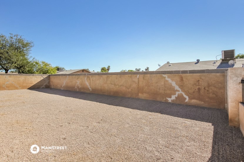 a retaining wall with gravel and a house in the background