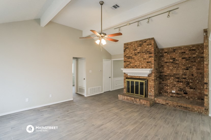 the living room with fireplace and ceiling fan