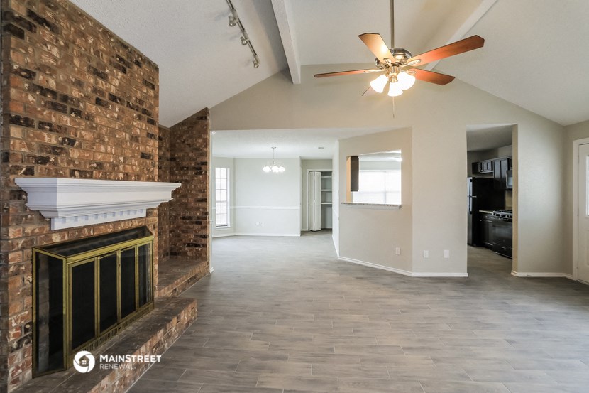 a living room with a fireplace and a ceiling fan