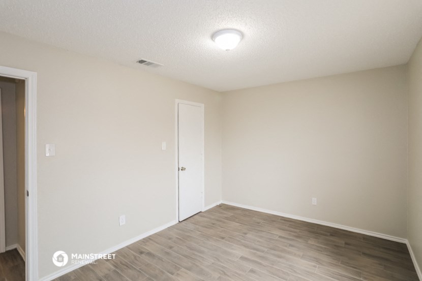the spacious living room with a door to the bedroom