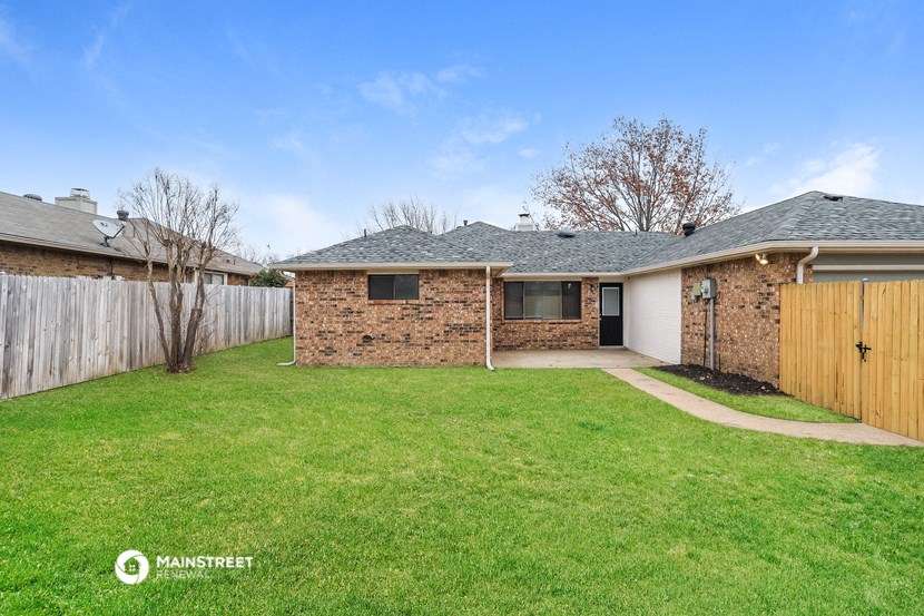 a brick house with a yard and a wooden fence