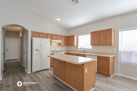 a kitchen with wooden cabinets and a white counter top and a refrigerator