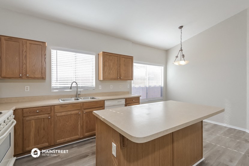 a kitchen with wooden cabinets and a white counter top