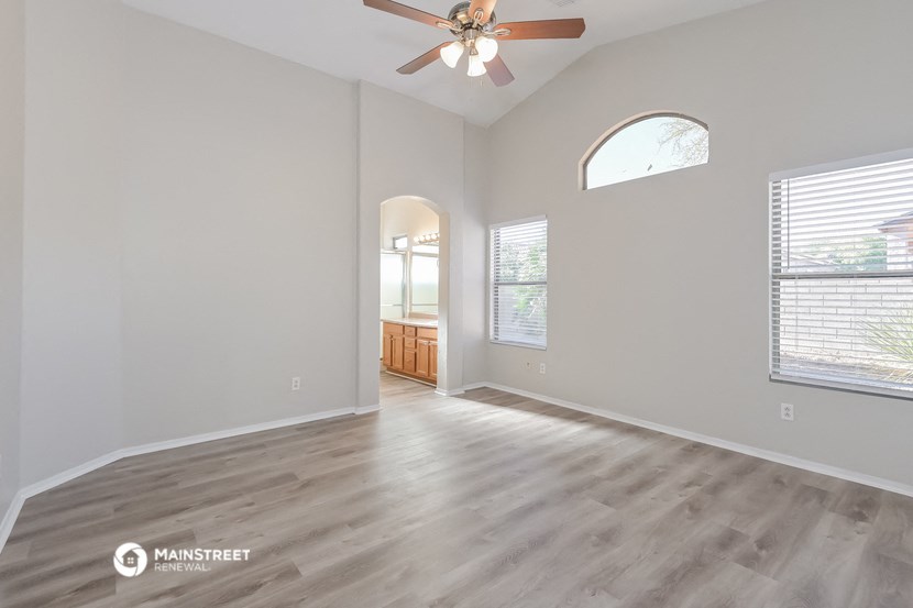 the living room of an empty house with a ceiling fan