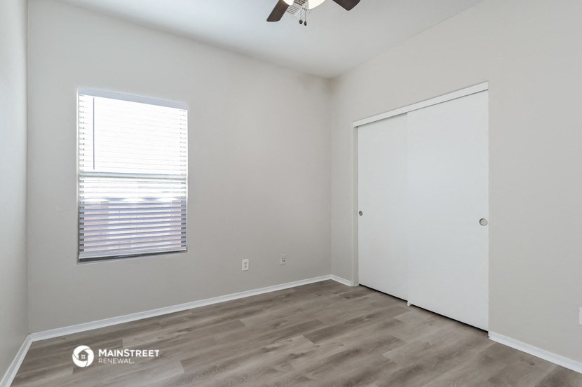 the living room of an apartment with a window and a closet