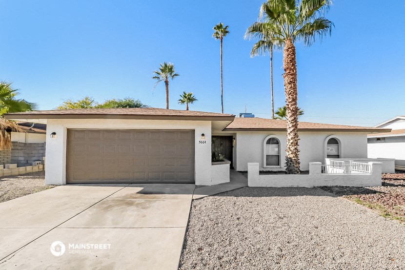 a white house with a palm tree and a garage door