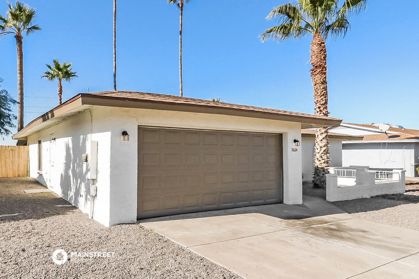 a garage door in front of a house with palm trees