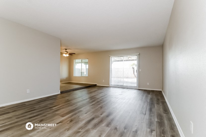 the spacious living room and dining room of an apartment
