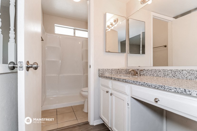 a bathroom with a shower and a sink and a mirror