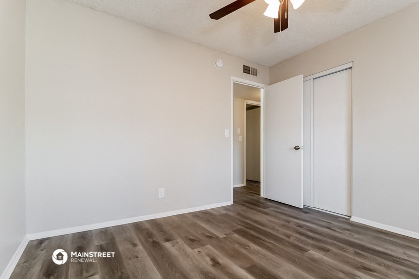 a living room with white walls and a ceiling fan