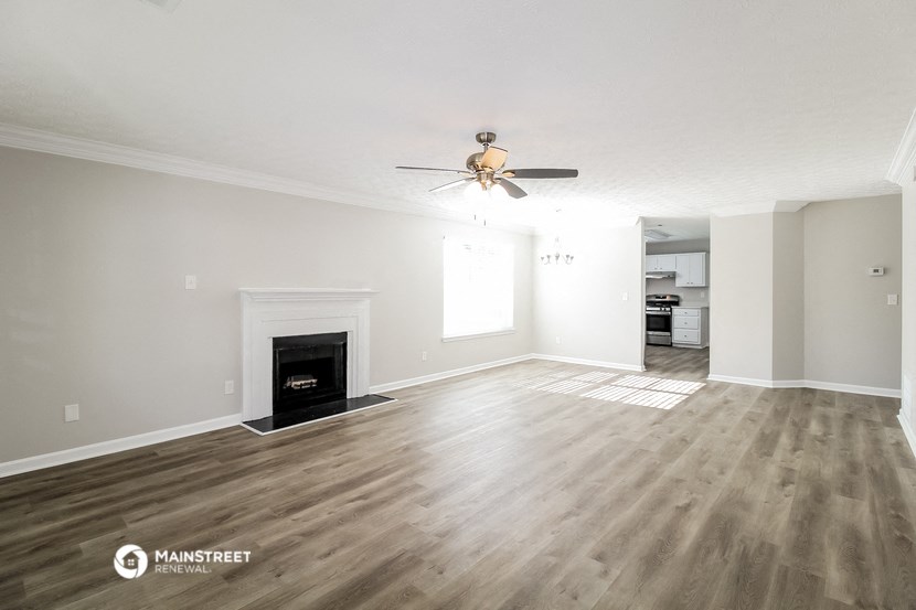 a living room with a fireplace and a ceiling fan