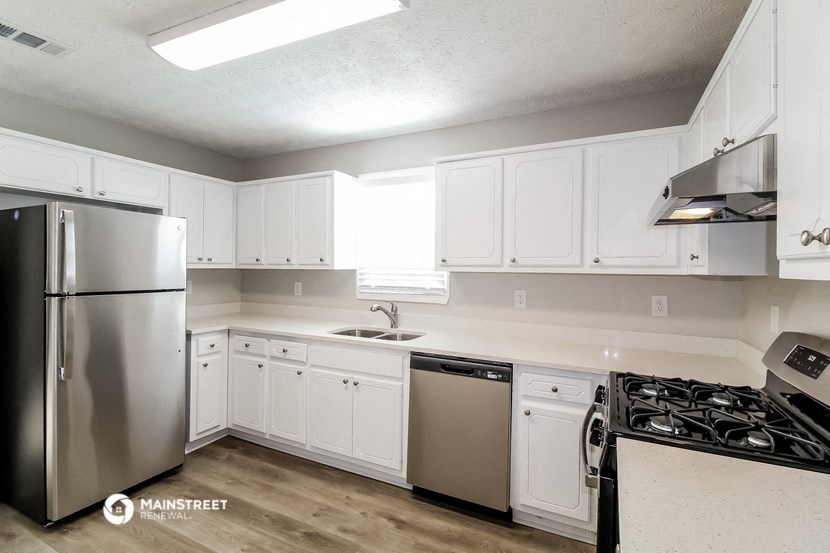 a kitchen with white cabinets and stainless steel appliances