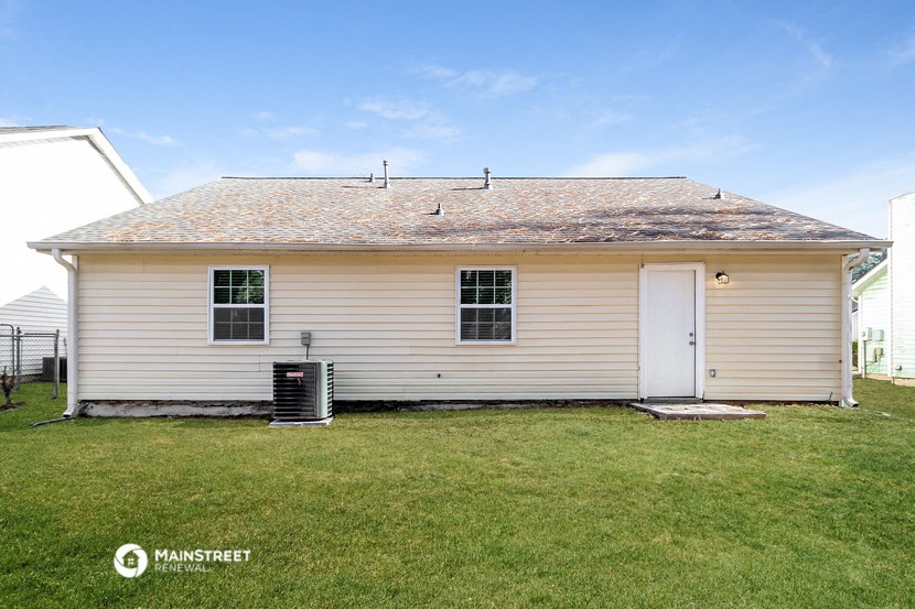 a small white house with a white door and a green lawn