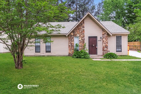 a small house with a lawn and a tree