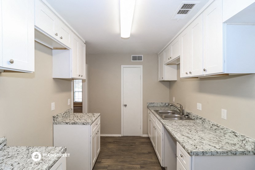 a kitchen with marble counter tops and white cabinets