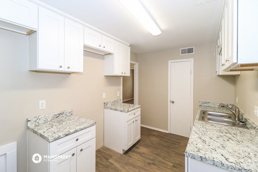 a kitchen with white cabinets and granite counter tops
