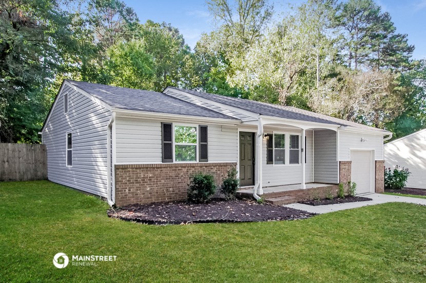 a small white house with a front yard and grass