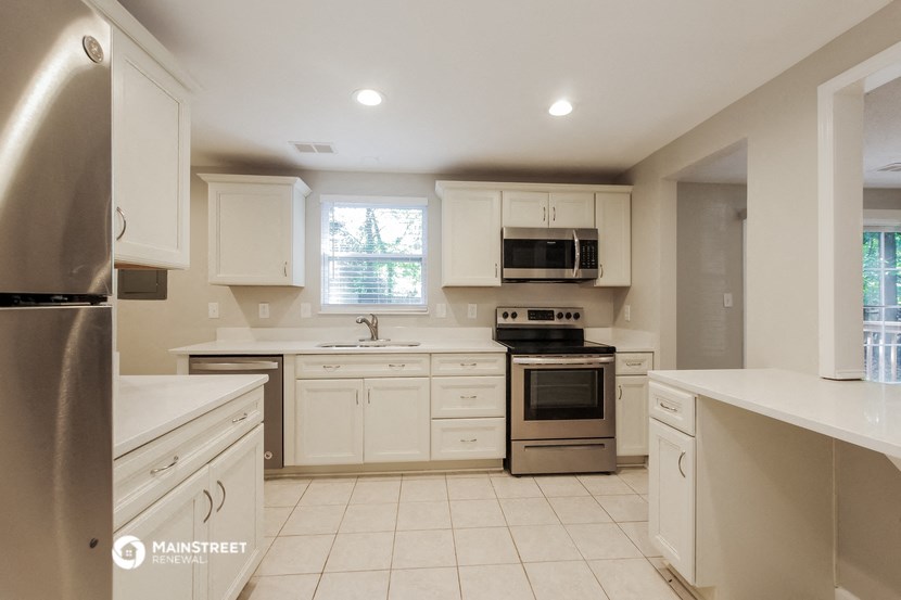 a kitchen with white cabinets and stainless steel appliances