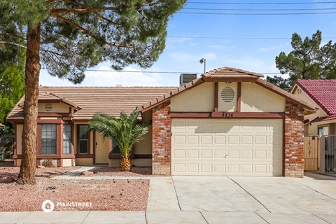 a house with a garage door and a palm tree