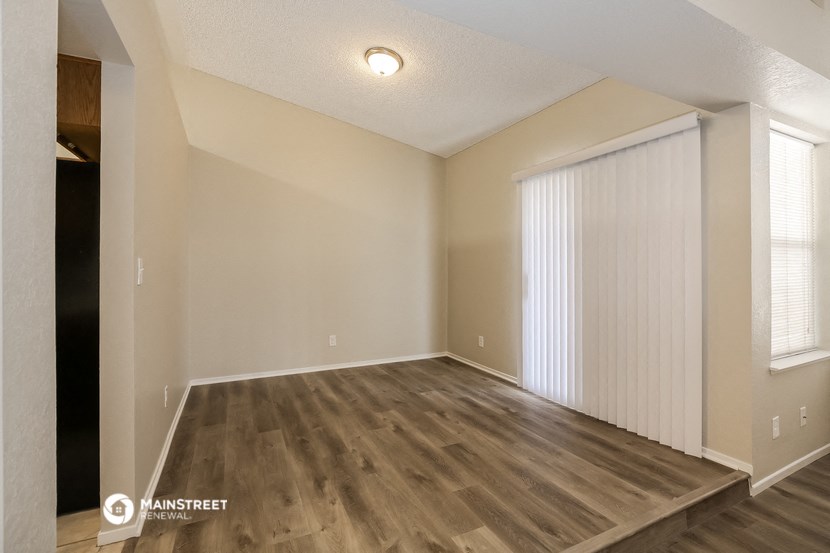 the spacious living room with vinyl flooring and a large window