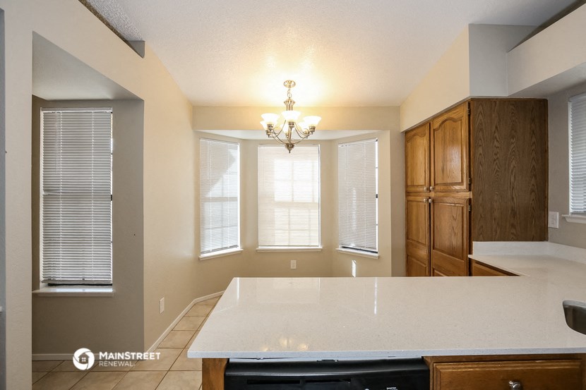 a kitchen with a white counter top and a window