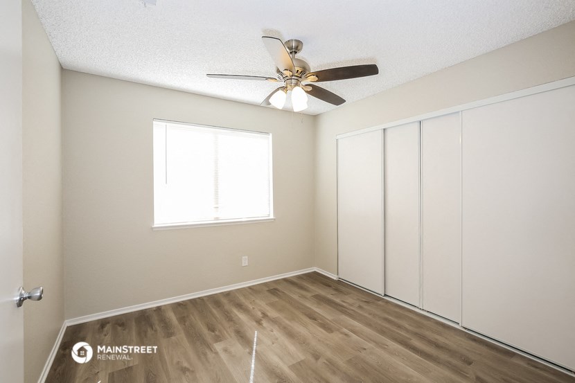 an empty room with a ceiling fan and a window