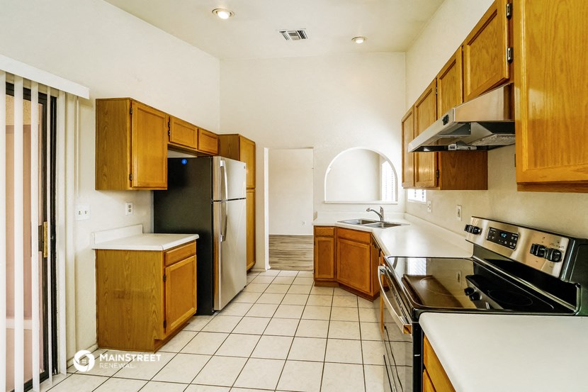 a kitchen with wooden cabinets and stainless steel appliances