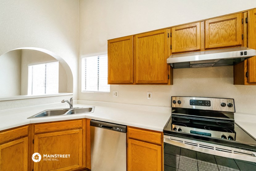 a kitchen with wooden cabinets and a stove and a sink