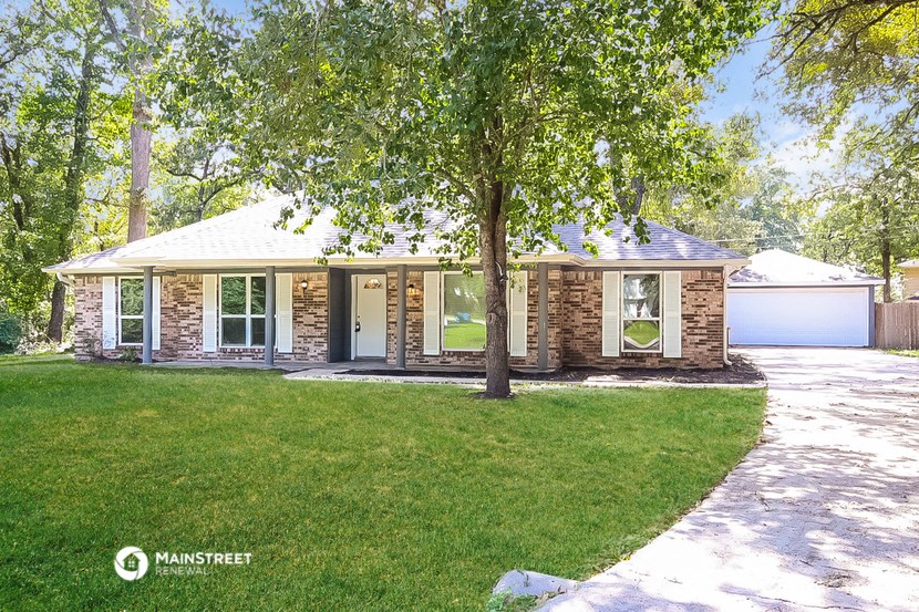 a small brick house with a tree in front of it