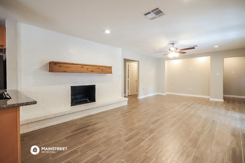 the living room with fireplace and wood flooring