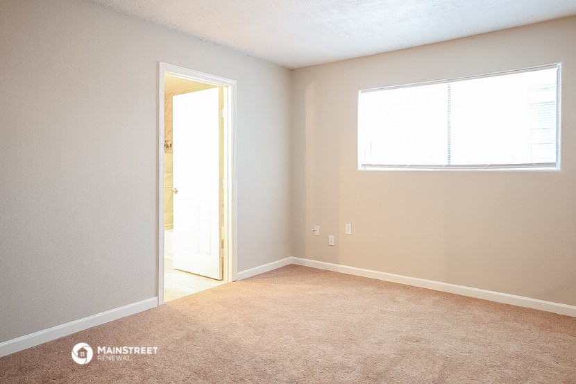 an empty room with a door and a window