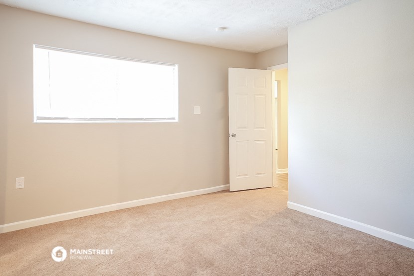 an empty room with a door and a window