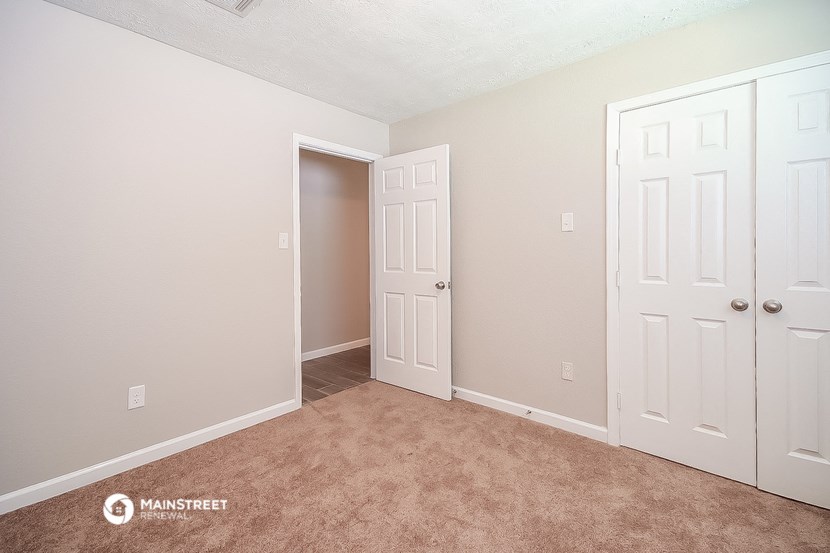 a bedroom with two closets and a door to a closet