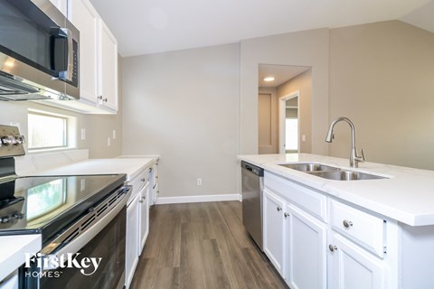 A kitchen with white cabinets and a stainless steel dishwasher.