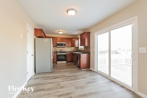 a kitchen with wooden cabinets and a door to a balcony