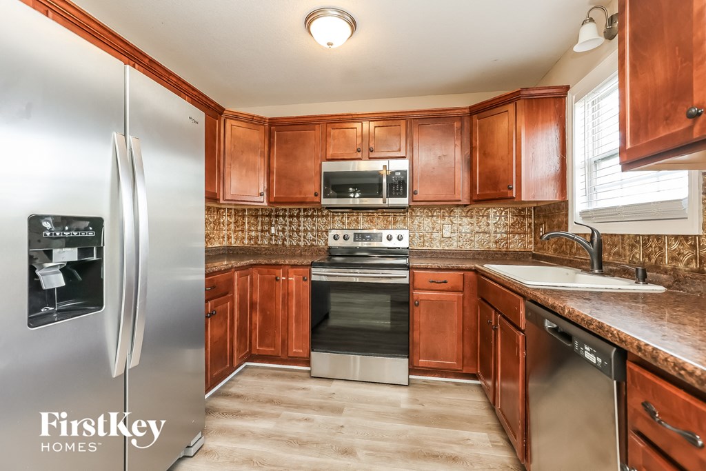 a kitchen with wooden cabinets and stainless steel appliances
