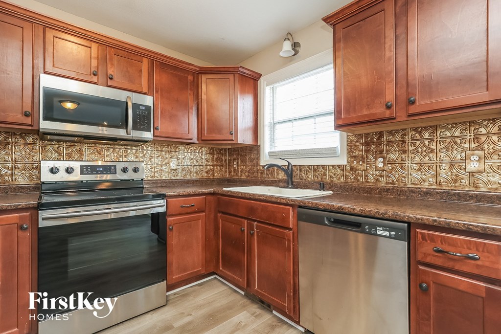 a kitchen with wooden cabinets and stainless steel appliances