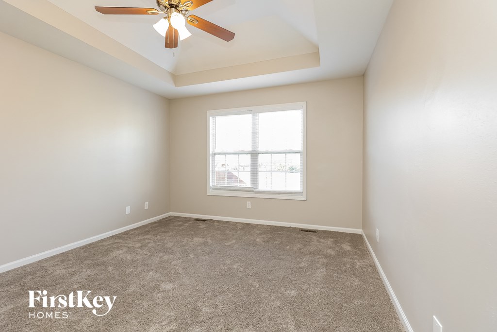 a empty room with a ceiling fan and a window