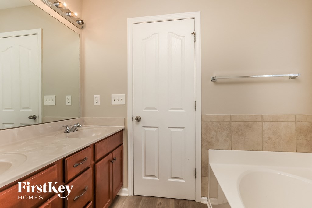 a bathroom with two sinks and a mirror and a white door