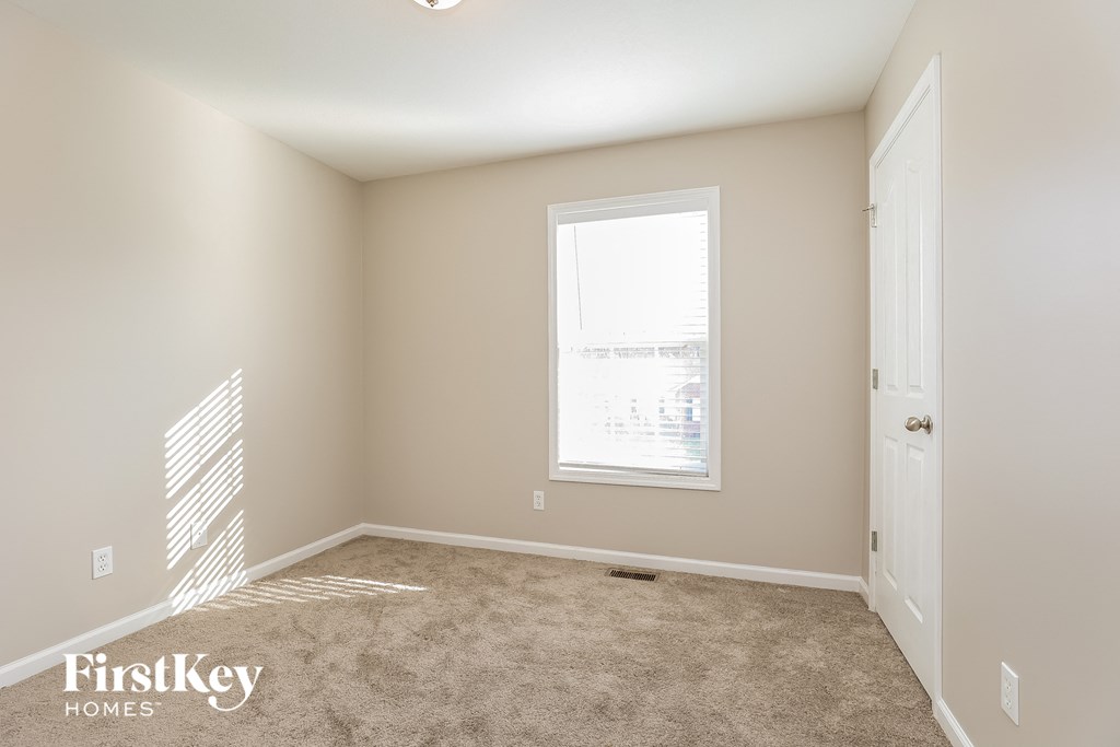 a bedroom with a carpeted floor and a window