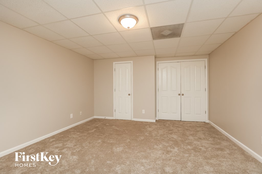 a empty room with two doors and a ceiling fan
