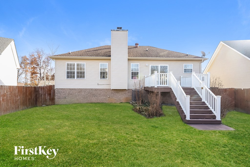 a white house with a backyard and a staircase