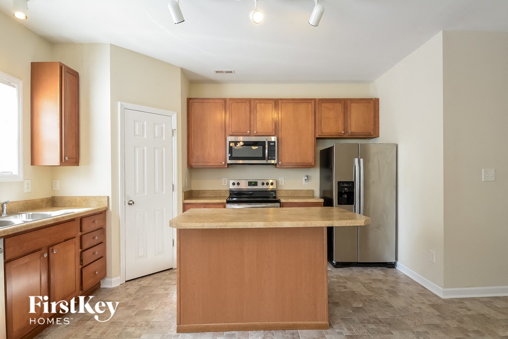 an empty kitchen with wooden cabinets and stainless steel appliances